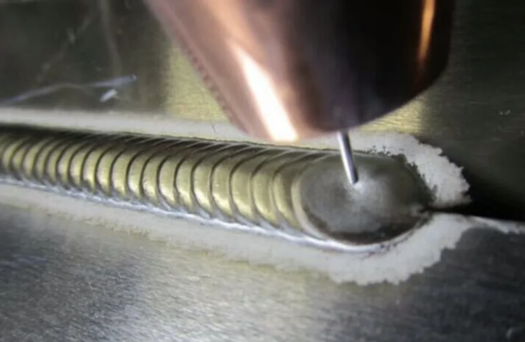 Close-up of precise aluminum TIG welding process with neat weld bead pattern